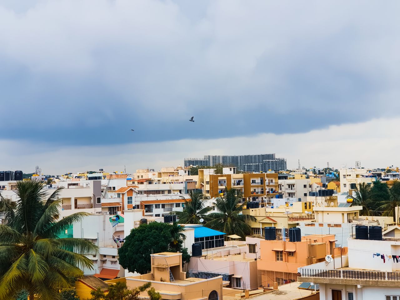 creative-02 Aerial view of Bengaluru's urban landscape with cloudy sky and buildings.