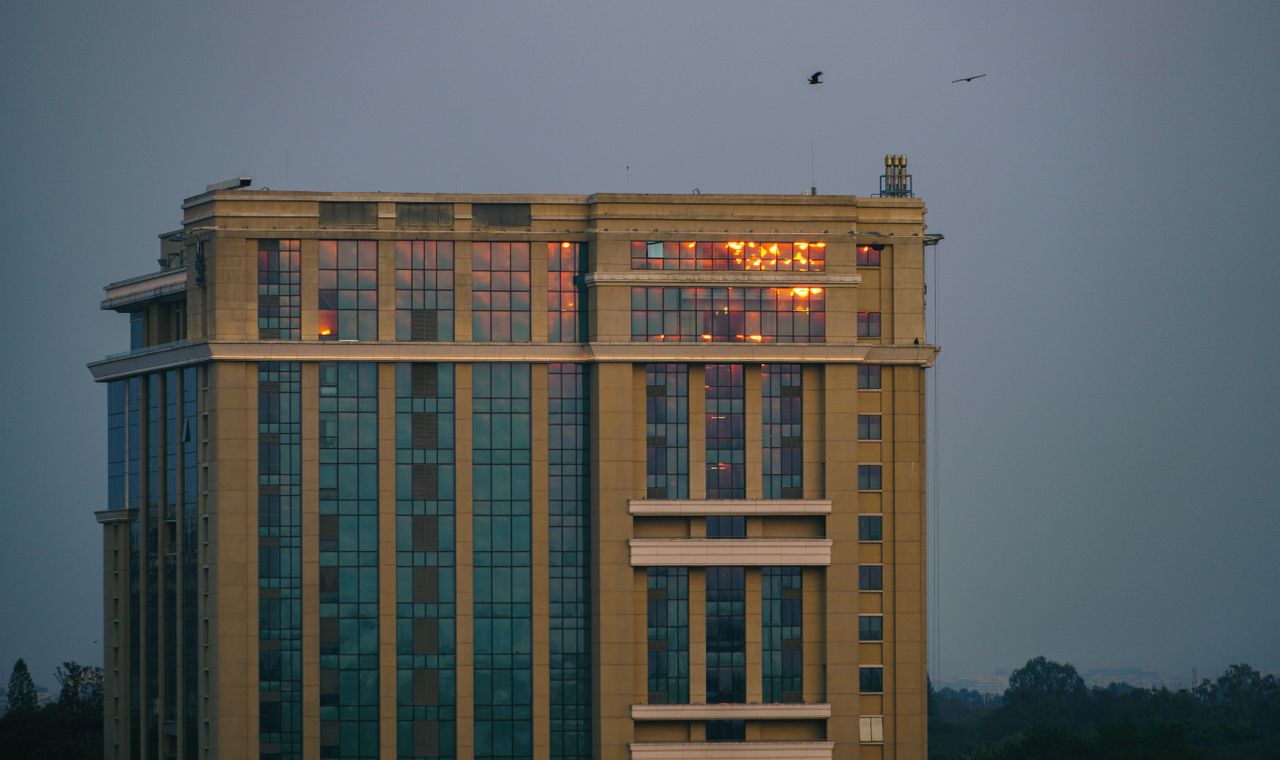 creative-01 A modern high-rise building with sunset reflections in Bengaluru, Karnataka, India.